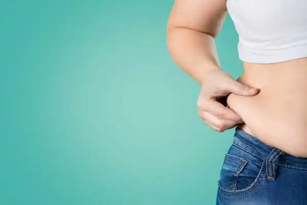 Image of woman pinching her love handles to show weight gain Marlow